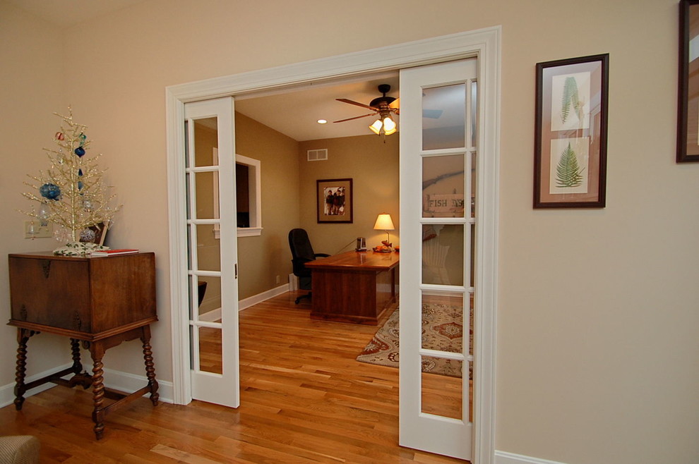Exempel på ett mellanstort klassiskt arbetsrum, med beige väggar, ljust trägolv och ett fristående skrivbord
