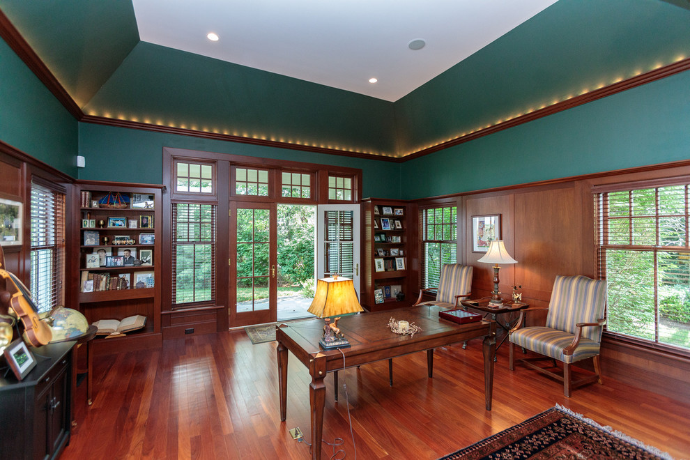 ボストンにあるラグジュアリーな広いトラディショナルスタイルのおしゃれなホームオフィス・書斎 (ライブラリー、緑の壁、無垢フローリング、自立型机、マルチカラーの床) の写真