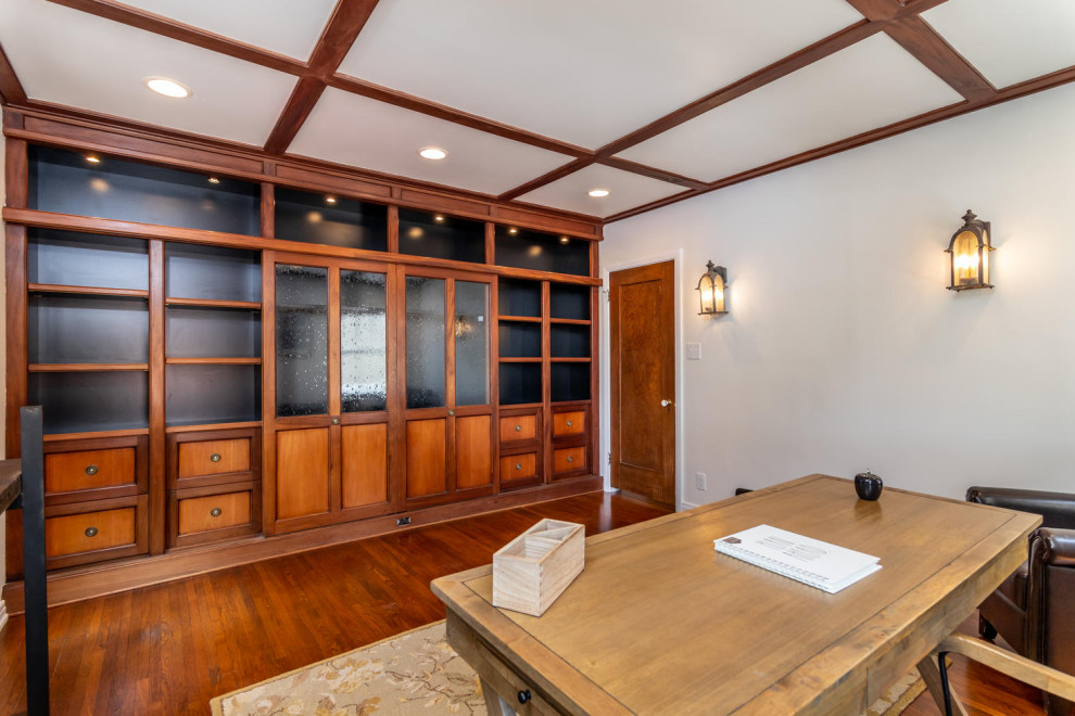 Photo of a home office in Los Angeles with white walls, medium hardwood flooring and brown floors.