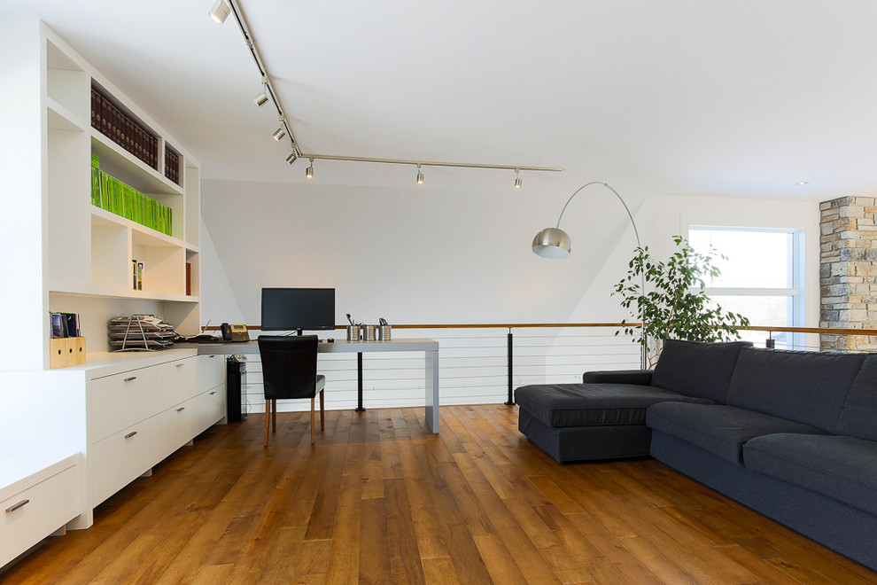 Immagine di un atelier contemporaneo di medie dimensioni con pareti bianche, pavimento in legno massello medio, nessun camino e scrivania incassata