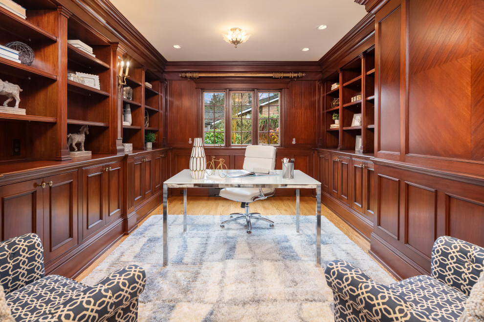 Ejemplo de despacho tradicional con paredes marrones, suelo de madera en tonos medios, escritorio independiente, suelo marrón, panelado y madera