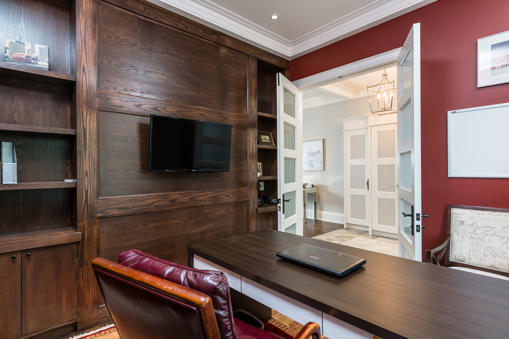 トロントにある高級な中くらいなトランジショナルスタイルのおしゃれなホームオフィス・書斎 (赤い壁、ラミネートの床、暖炉なし、自立型机、茶色い床) の写真