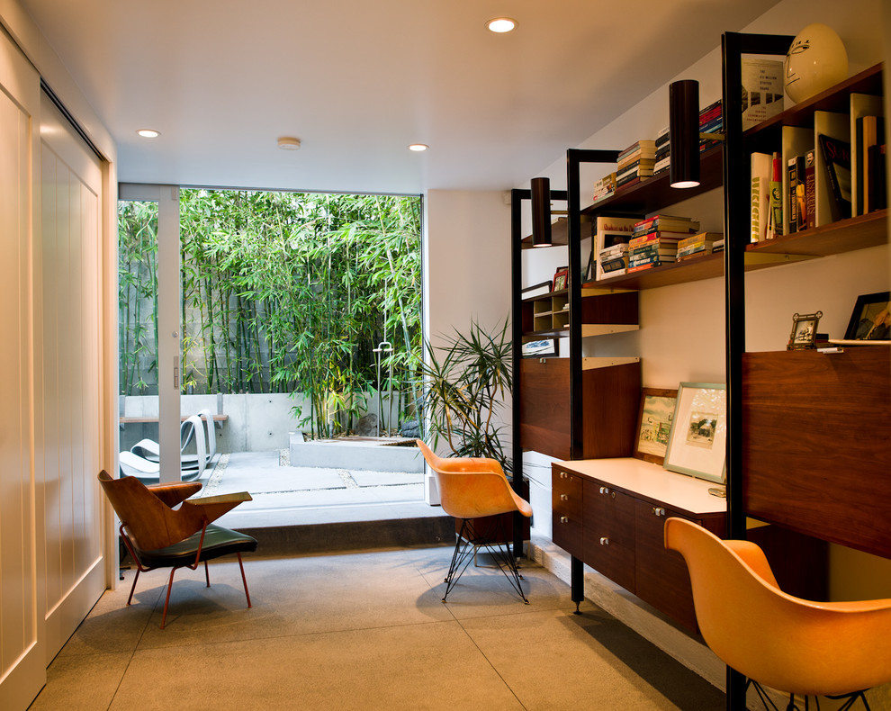 Modern inredning av ett arbetsrum, med betonggolv och ett inbyggt skrivbord