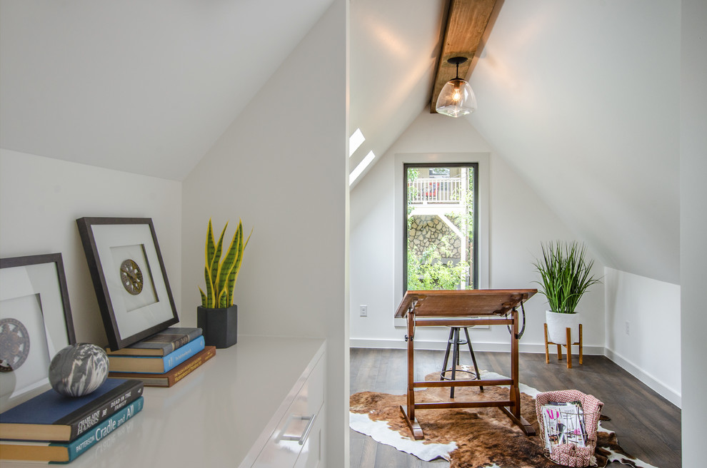 Landhaus Arbeitszimmer mit Studio, weißer Wandfarbe, dunklem Holzboden, freistehendem Schreibtisch und braunem Boden in Austin