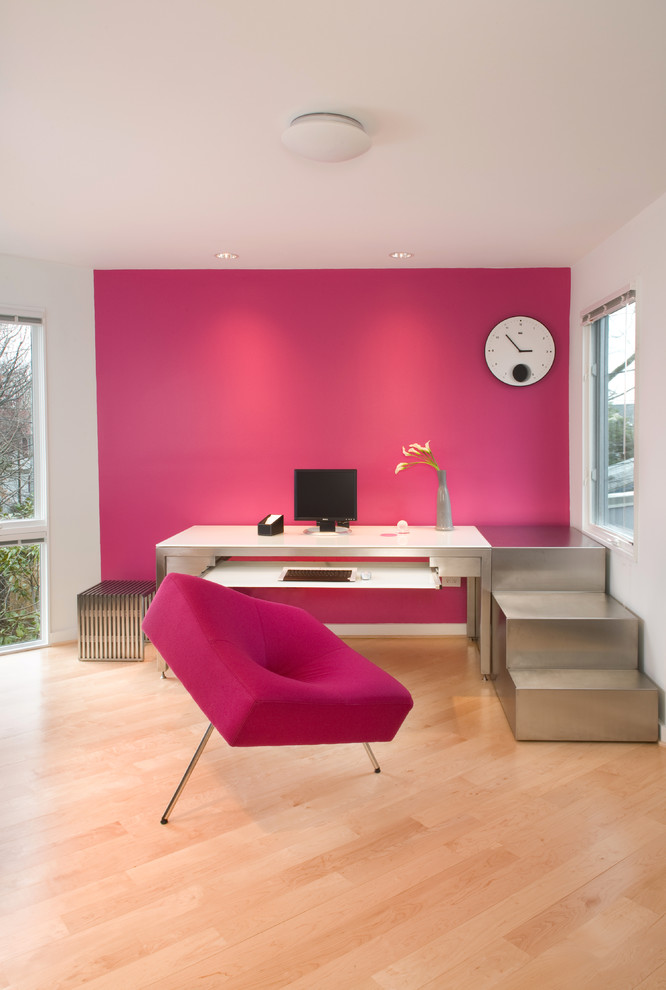 На фото: кабинет в стиле модернизм с розовыми стенами, отдельно стоящим рабочим столом, светлым паркетным полом и бежевым полом с