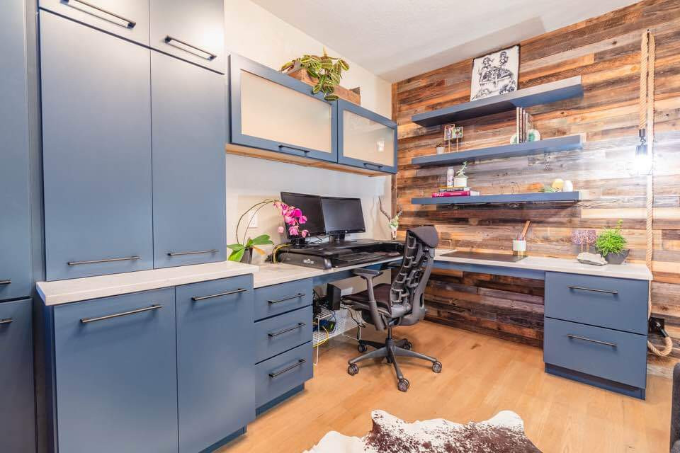 Inredning av ett industriellt mellanstort arbetsrum, med ljust trägolv och ett inbyggt skrivbord