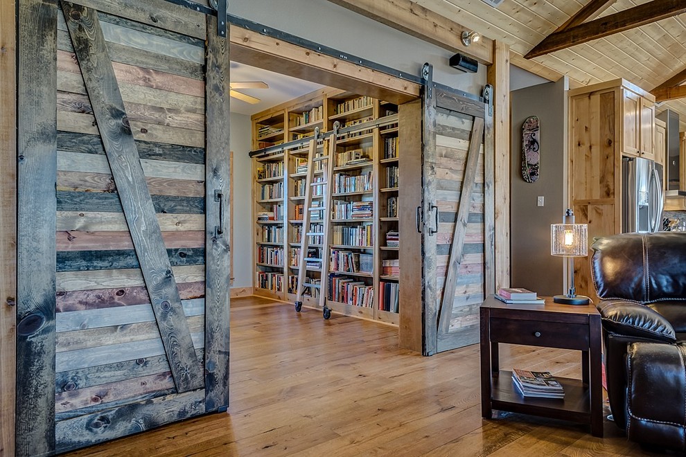 ダラスにある広いカントリー風のおしゃれなホームオフィス・書斎 (ライブラリー、グレーの壁、無垢フローリング、自立型机) の写真