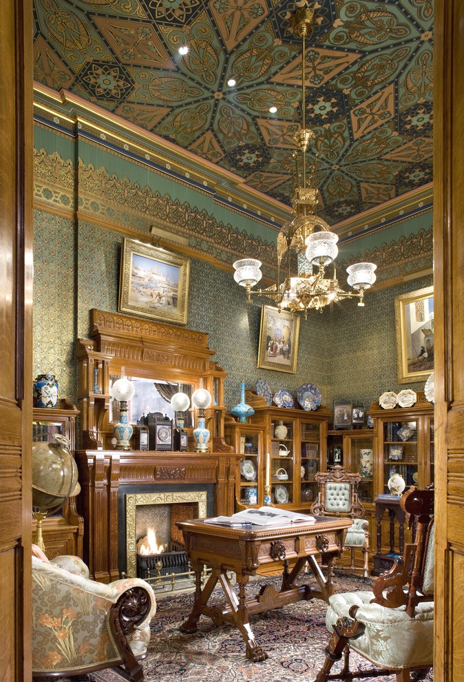 Cette image montre un bureau traditionnel de taille moyenne avec un mur multicolore, parquet clair, une cheminée standard et un manteau de cheminée en métal.