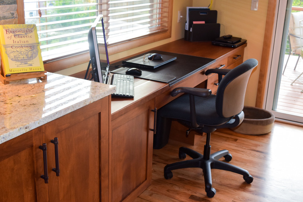 Foto de despacho clásico renovado pequeño con paredes amarillas, suelo de madera en tonos medios y escritorio empotrado