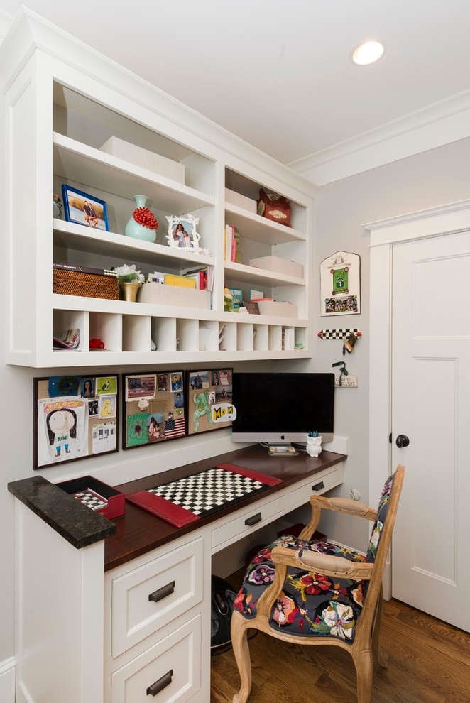 Modelo de despacho clásico pequeño con paredes blancas, suelo de madera en tonos medios y escritorio empotrado