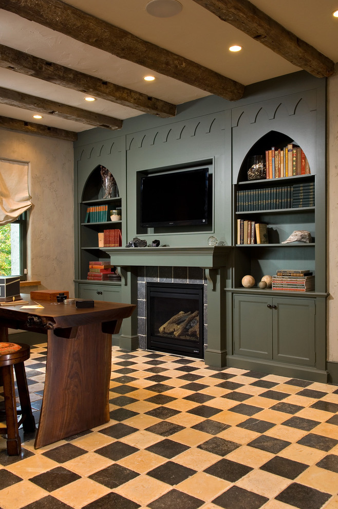 ニューヨークにある高級な地中海スタイルのおしゃれなホームオフィス・書斎 (標準型暖炉、タイルの暖炉まわり、自立型机、マルチカラーの床) の写真