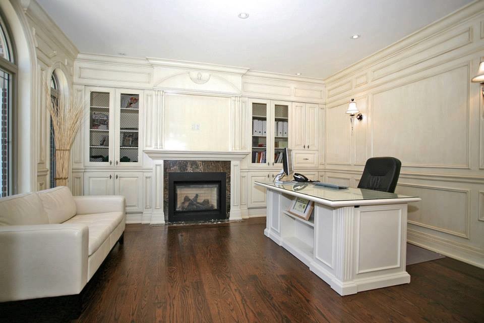 Esempio di un grande ufficio classico con pareti beige, pavimento in legno massello medio, camino classico e scrivania autoportante