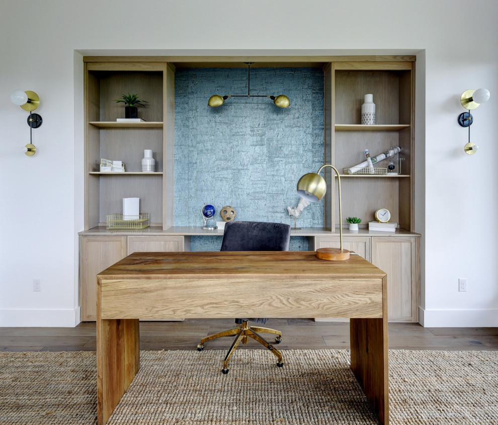 Diseño de despacho contemporáneo sin chimenea con paredes blancas, suelo de madera oscura y escritorio independiente