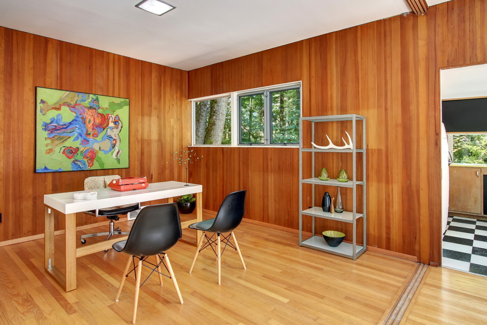 Diseño de despacho retro con suelo de madera clara y escritorio independiente