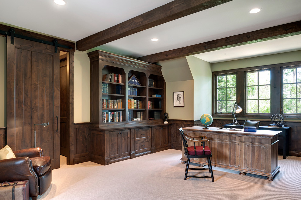 Large rustic study in Minneapolis with beige walls, carpet and a freestanding desk.