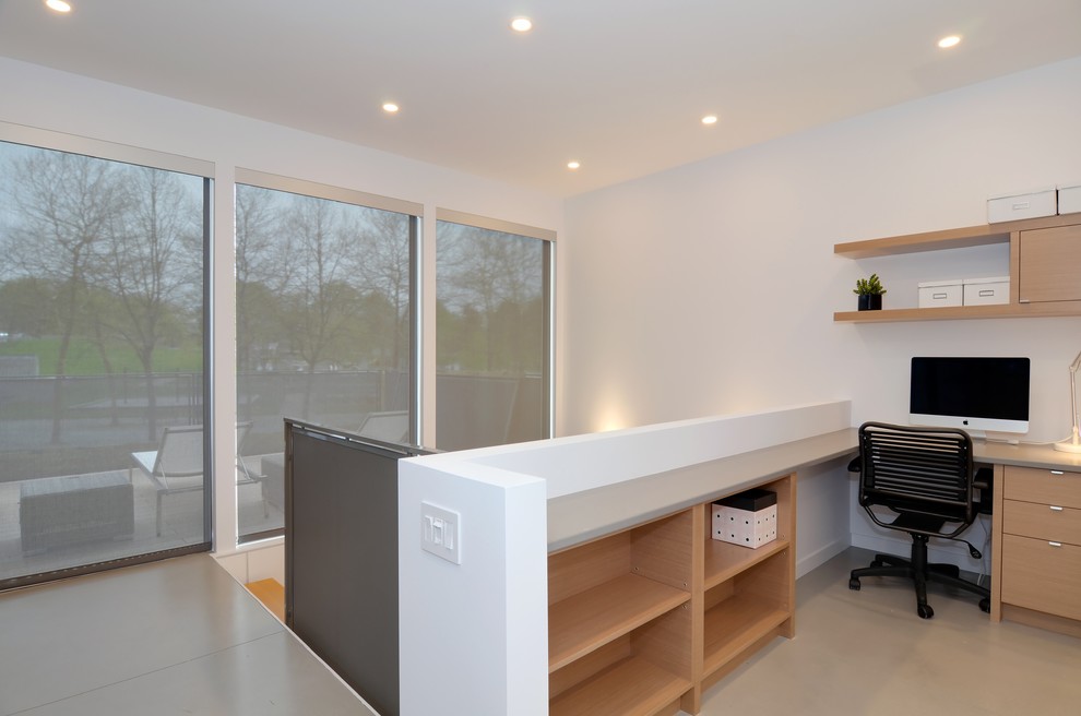 Immagine di un piccolo ufficio scandinavo con pareti bianche, pavimento in cemento, nessun camino e scrivania incassata