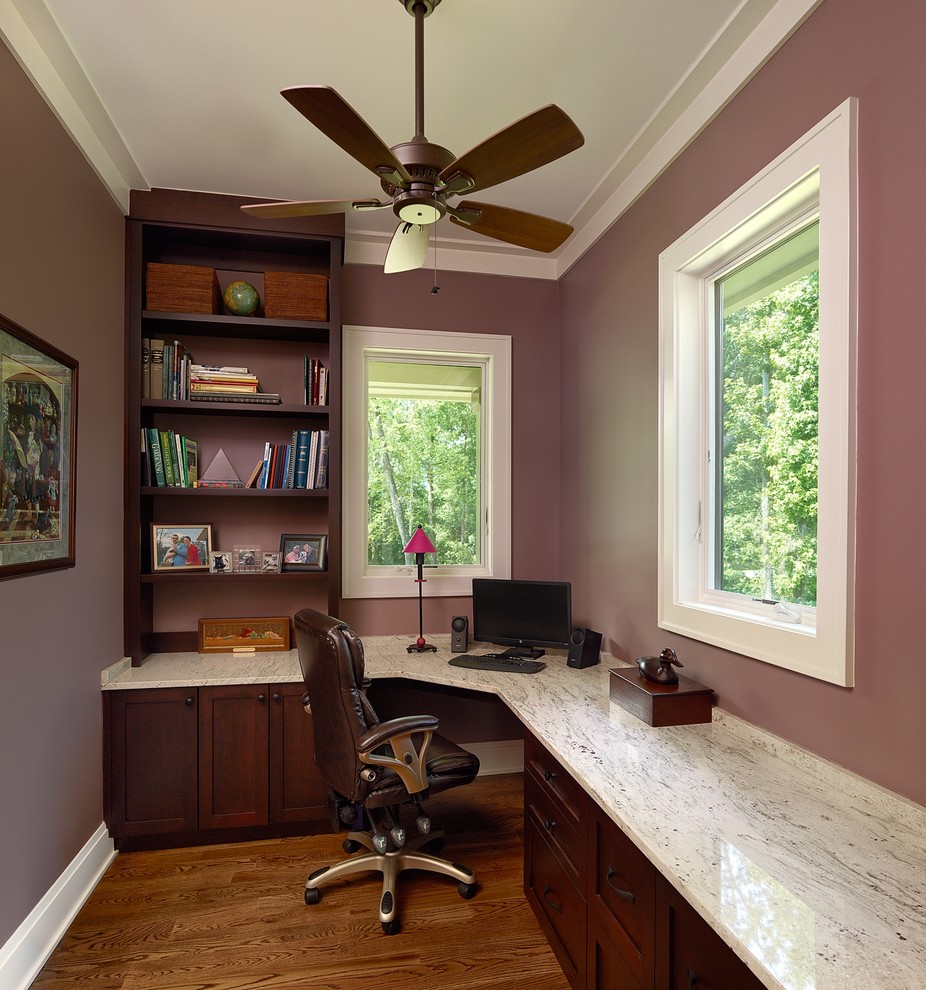 Réalisation d'un bureau design avec un mur violet, un sol en bois brun et un bureau intégré.