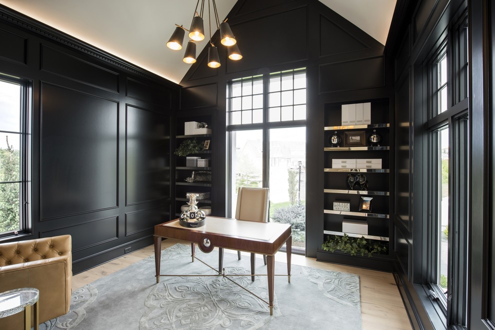 Diseño de despacho clásico renovado de tamaño medio con paredes negras, suelo de madera clara y escritorio independiente
