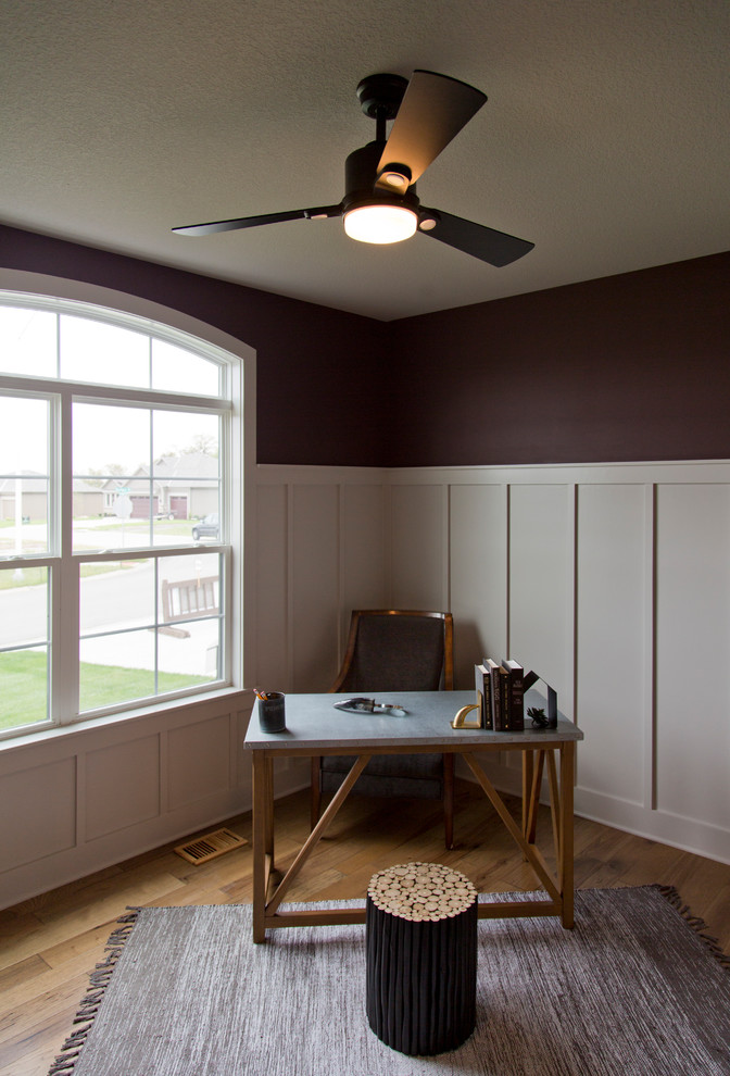 Inredning av ett rustikt mellanstort arbetsrum, med lila väggar, mellanmörkt trägolv, ett fristående skrivbord och brunt golv