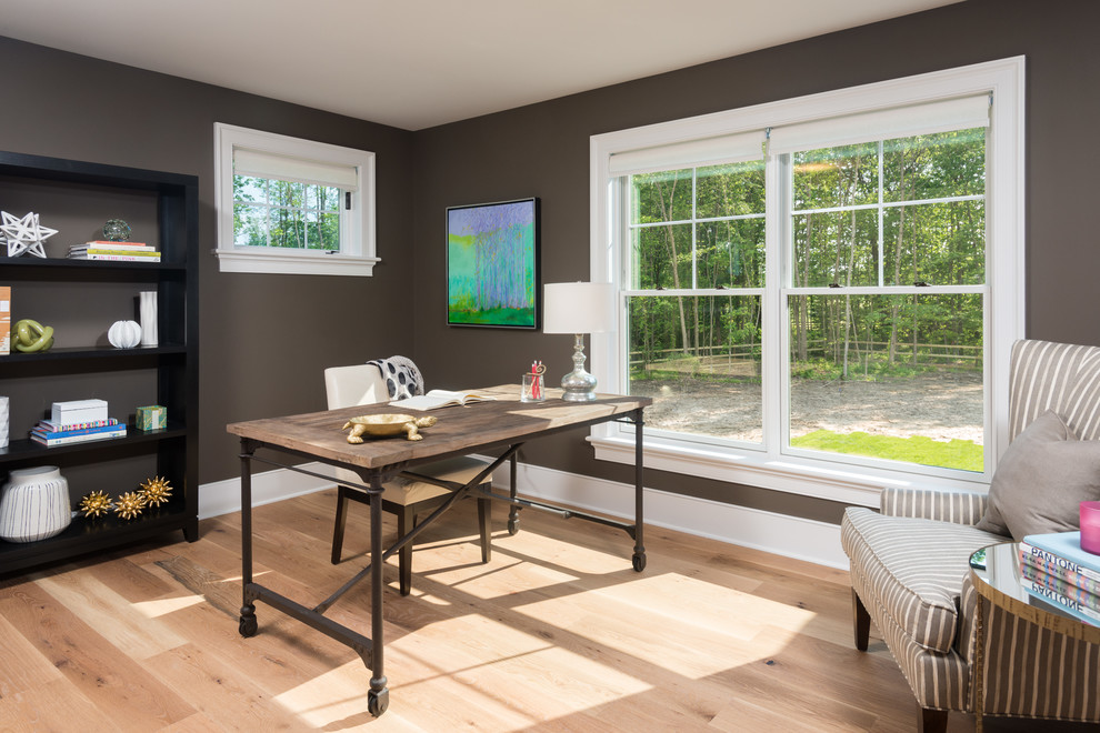 Foto de estudio de estilo de casa de campo de tamaño medio sin chimenea con paredes grises, suelo de madera clara, escritorio independiente y suelo marrón