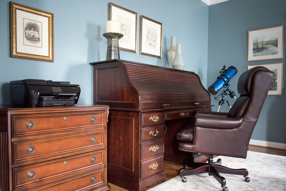 Ispirazione per un ufficio tradizionale di medie dimensioni con pareti blu, pavimento in legno massello medio, scrivania autoportante e pavimento marrone