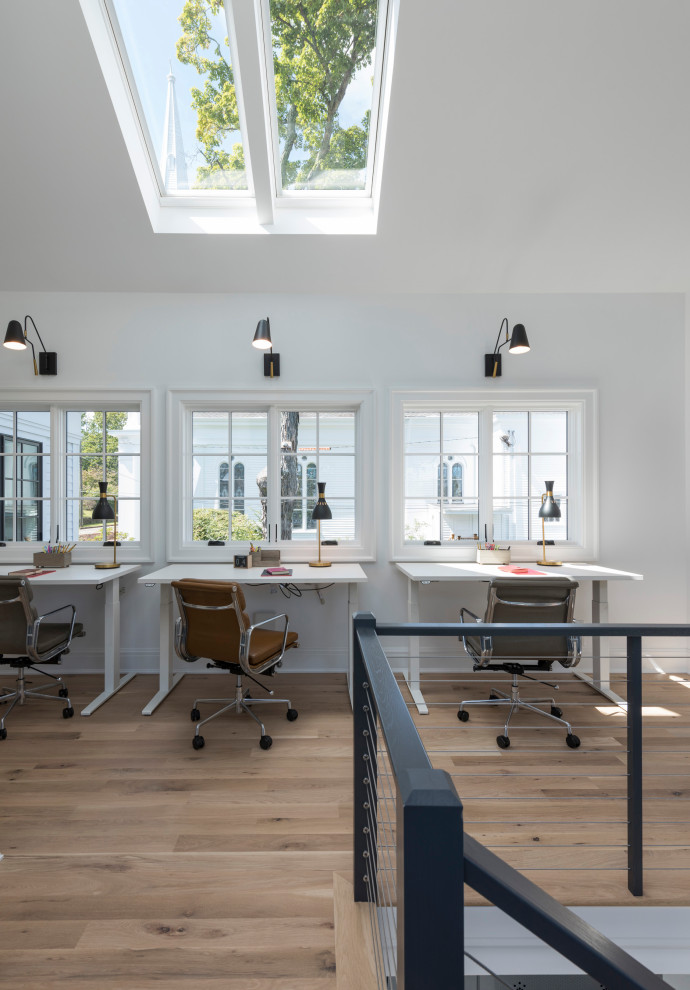Cette image montre un grand bureau traditionnel avec un mur blanc, un sol en bois brun, un bureau indépendant et un sol beige.