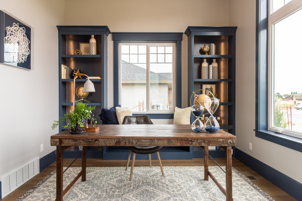 Foto de despacho de estilo americano de tamaño medio sin chimenea con paredes beige, suelo de madera en tonos medios, escritorio independiente y suelo marrón