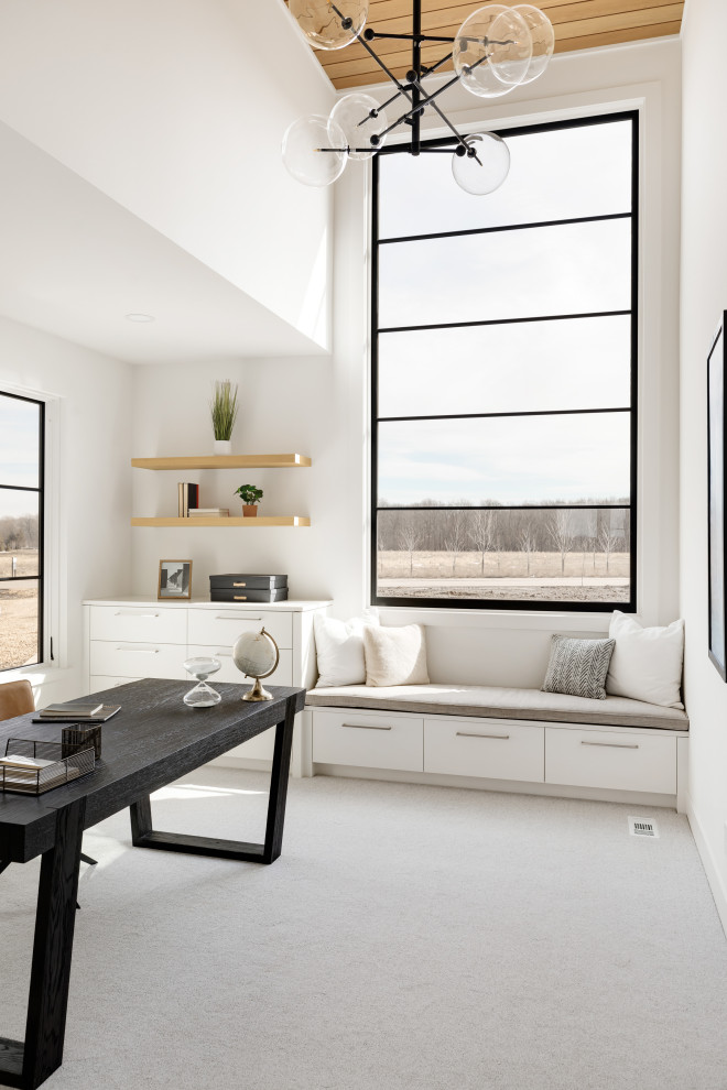 На фото: кабинет в современном стиле с белыми стенами, ковровым покрытием, отдельно стоящим рабочим столом и серым полом с