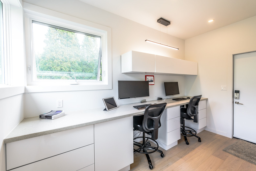 Kleines Modernes Arbeitszimmer mit weißer Wandfarbe, braunem Holzboden und Einbau-Schreibtisch in Toronto