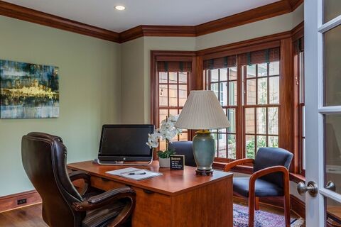 Idée de décoration pour un bureau tradition de taille moyenne avec un mur vert, sol en stratifié, un bureau indépendant et un sol marron.