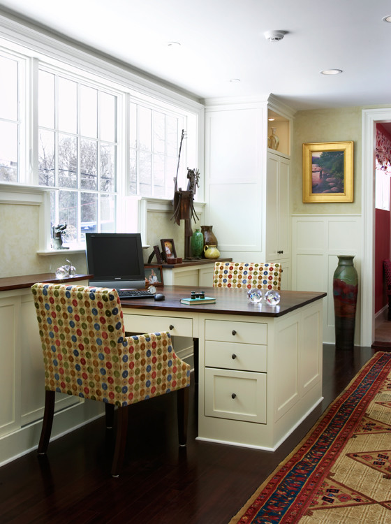 Diseño de despacho tradicional grande con paredes beige, suelo de madera oscura, escritorio empotrado y suelo marrón