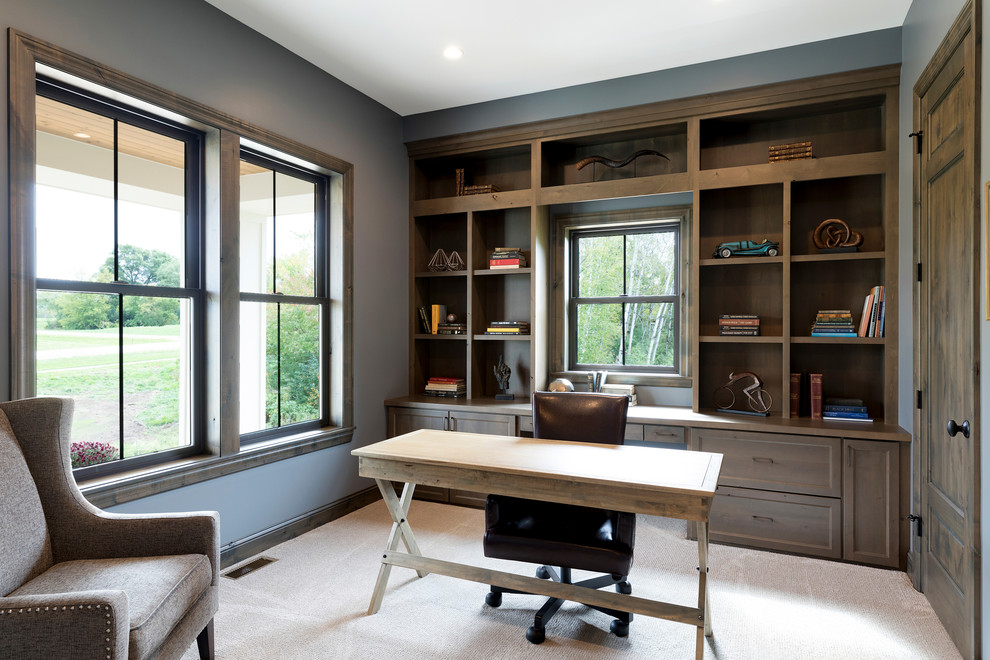 Inspiration för klassiska hemmabibliotek, med heltäckningsmatta, ett fristående skrivbord och grå väggar