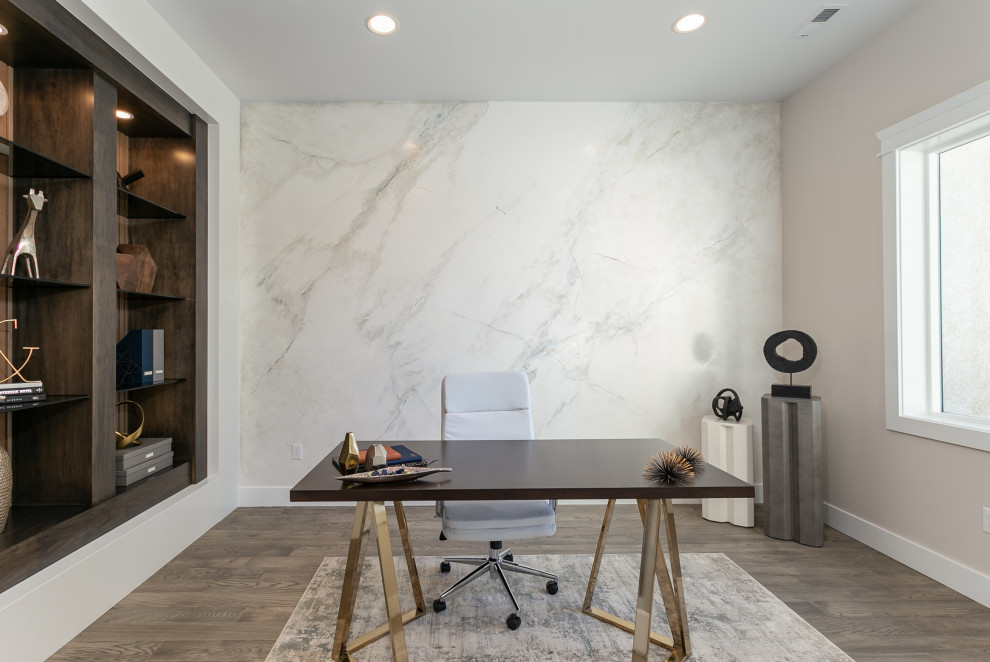 This is an example of a medium sized modern home office in Seattle with white walls and light hardwood flooring.