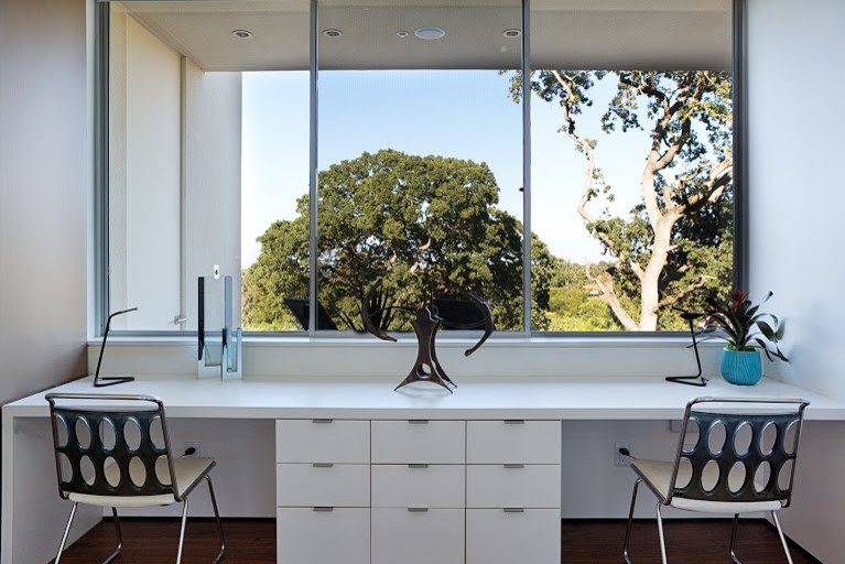 Стильный дизайн: большой кабинет в стиле модернизм с белыми стенами и встроенным рабочим столом - последний тренд