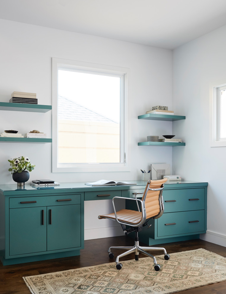 Cette image montre un bureau traditionnel de taille moyenne avec un mur blanc, un sol en bois brun, un bureau intégré et un sol marron.