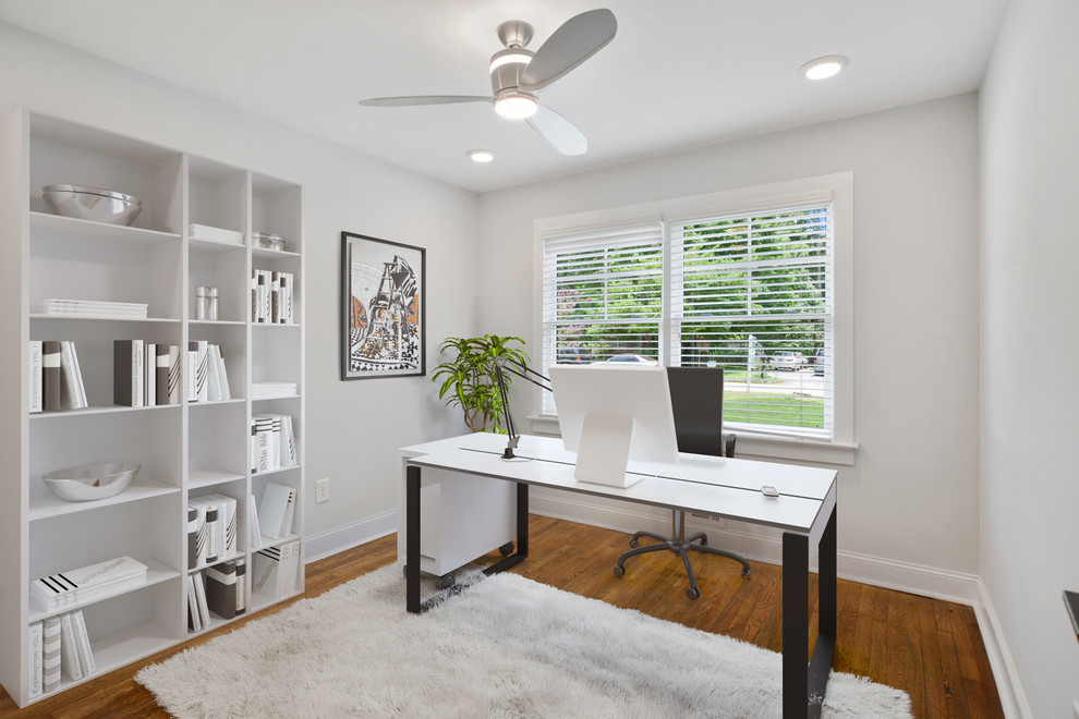 Modernes Lesezimmer mit weißer Wandfarbe, braunem Holzboden, freistehendem Schreibtisch und braunem Boden in Atlanta