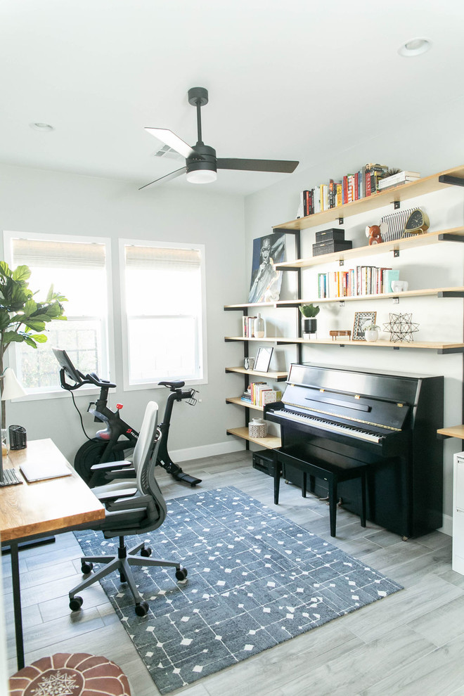 Modelo de despacho moderno de tamaño medio con paredes blancas, escritorio independiente y suelo gris