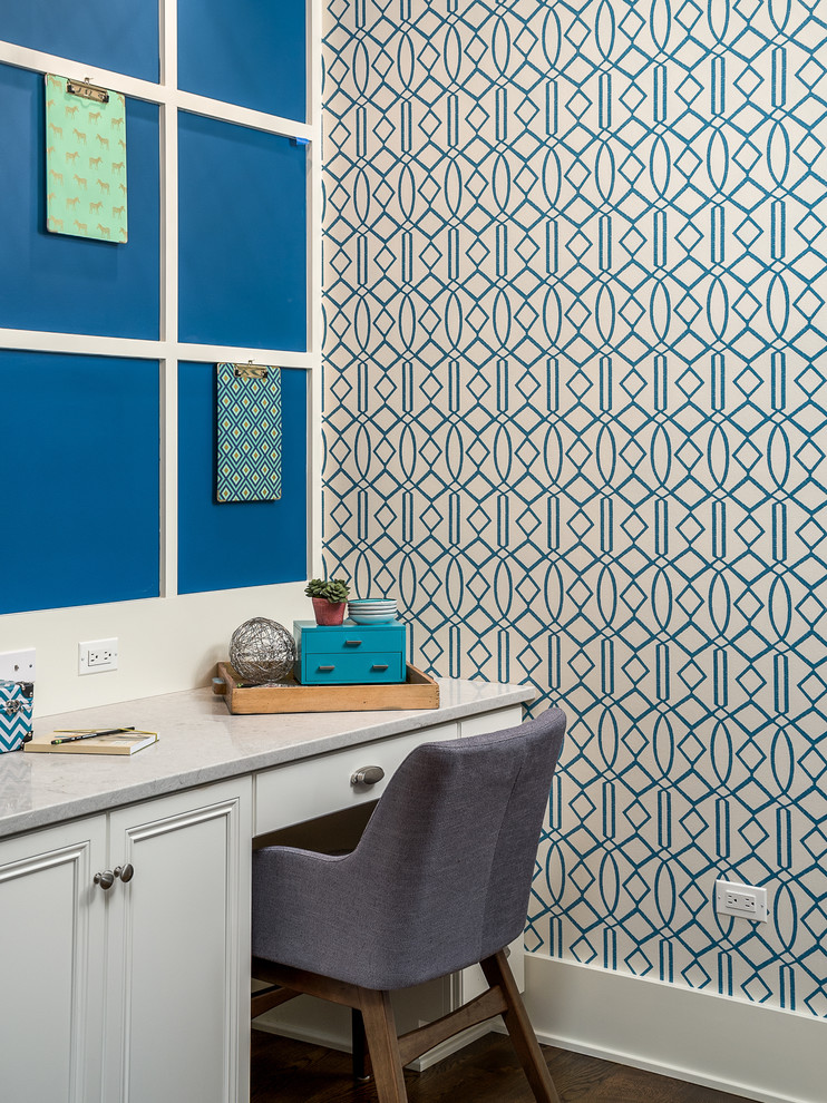 Foto på ett stort funkis hobbyrum, med blå väggar, mörkt trägolv, ett inbyggt skrivbord och brunt golv