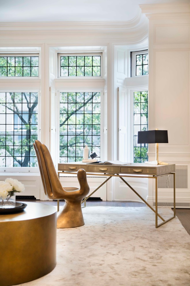 Trendy freestanding desk dark wood floor and brown floor home office photo in New York with white walls