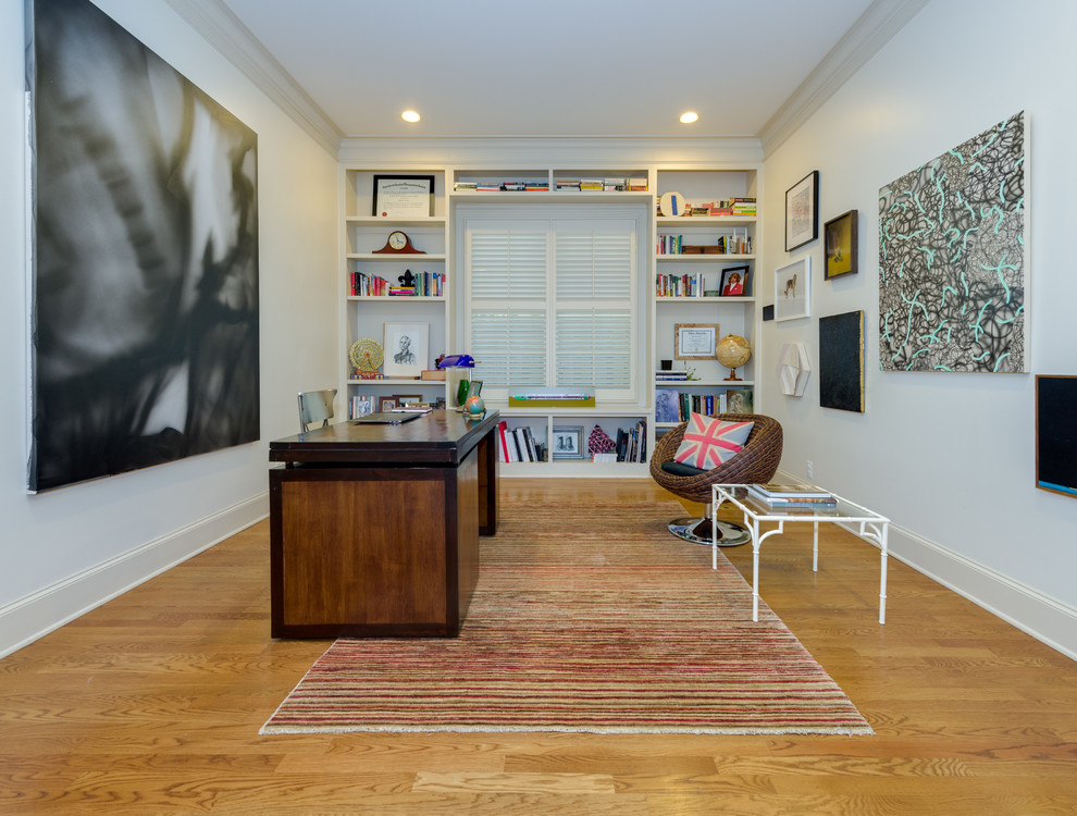 Klassisches Arbeitszimmer ohne Kamin mit weißer Wandfarbe, hellem Holzboden und freistehendem Schreibtisch in Dallas
