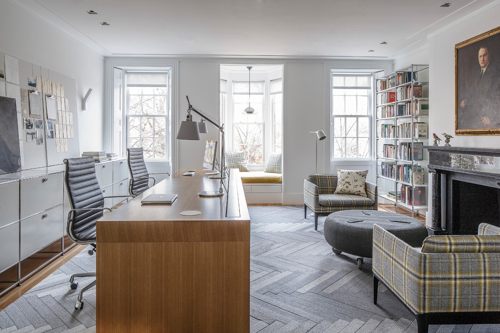 Идея дизайна: домашняя библиотека в стиле неоклассика (современная классика) с белыми стенами, стандартным камином и отдельно стоящим рабочим столом