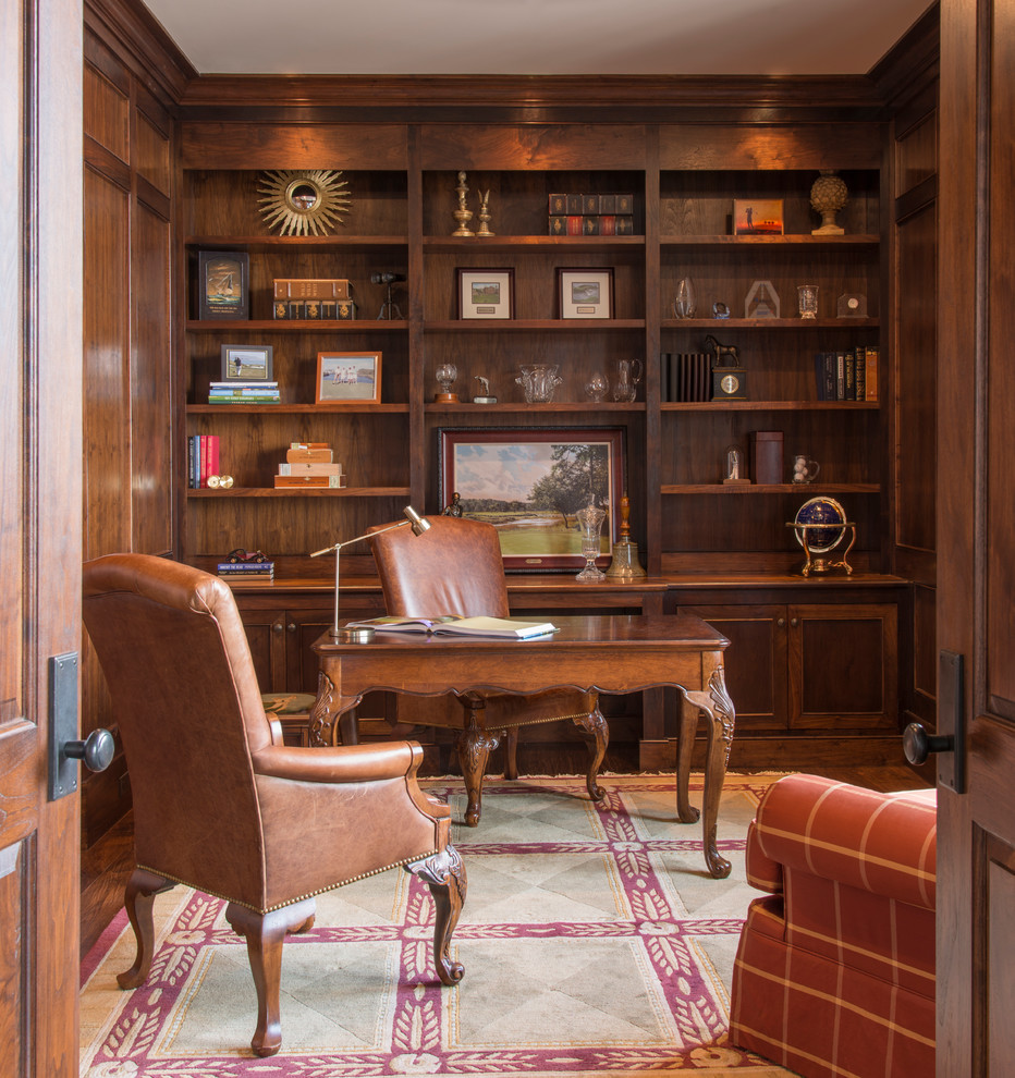 Ejemplo de despacho tradicional de tamaño medio sin chimenea con escritorio independiente, paredes marrones y suelo de madera en tonos medios