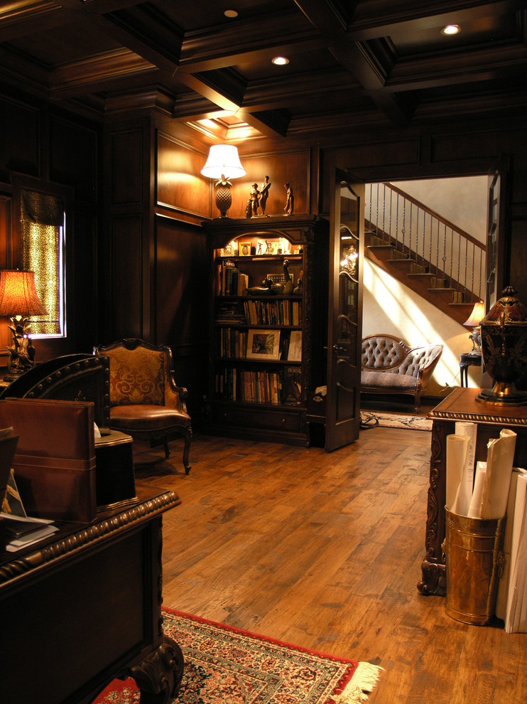 Exemple d'un bureau chic de taille moyenne avec un mur beige, un sol en bois brun, une cheminée standard, un manteau de cheminée en plâtre, un bureau indépendant et un sol marron.
