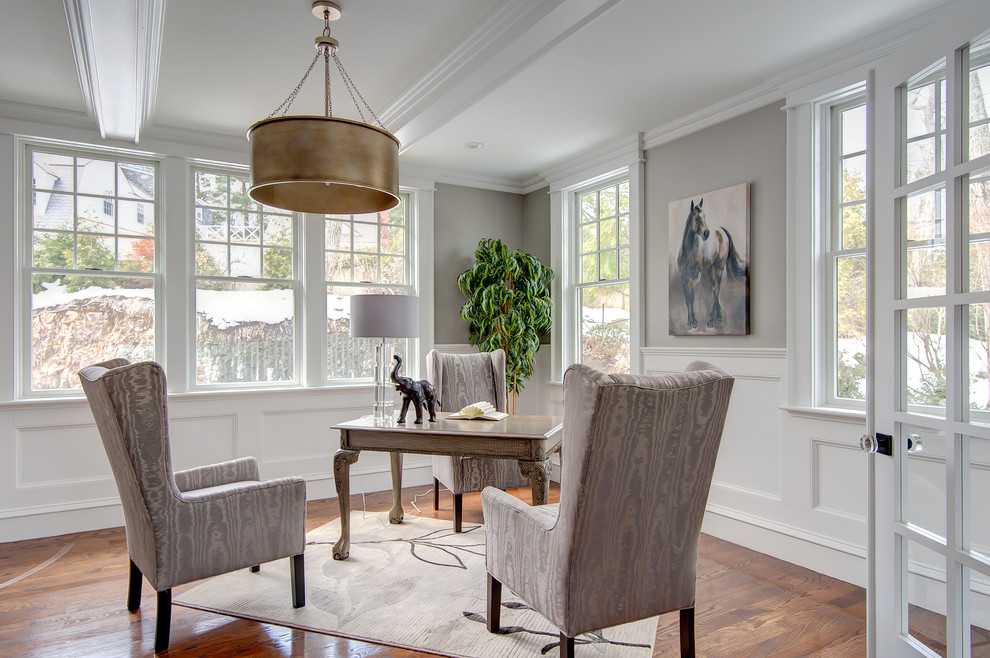 Mid-sized elegant freestanding desk dark wood floor and multicolored floor home studio photo in Boston with gray walls