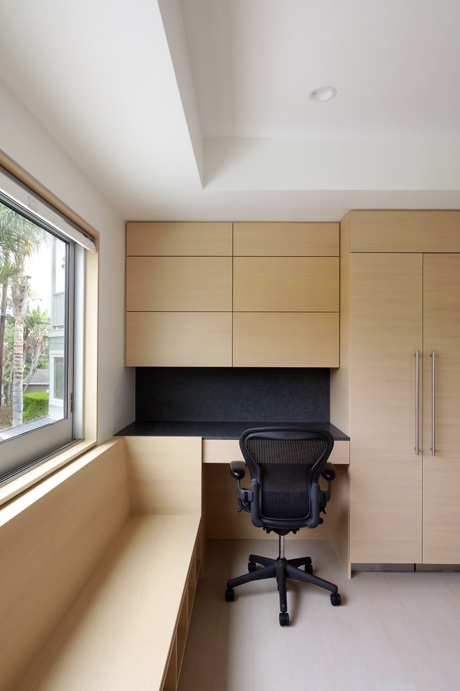 Nordisches Arbeitszimmer mit weißer Wandfarbe, hellem Holzboden, Einbau-Schreibtisch und weißem Boden in Los Angeles