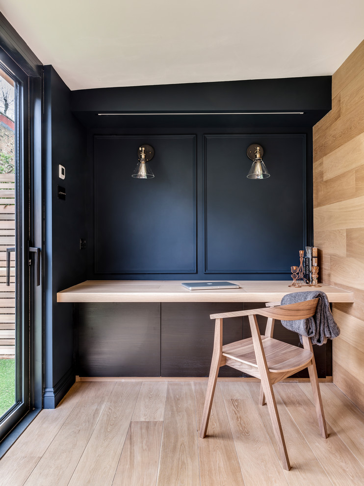 Diseño de despacho nórdico con paredes negras, suelo de madera clara y suelo beige