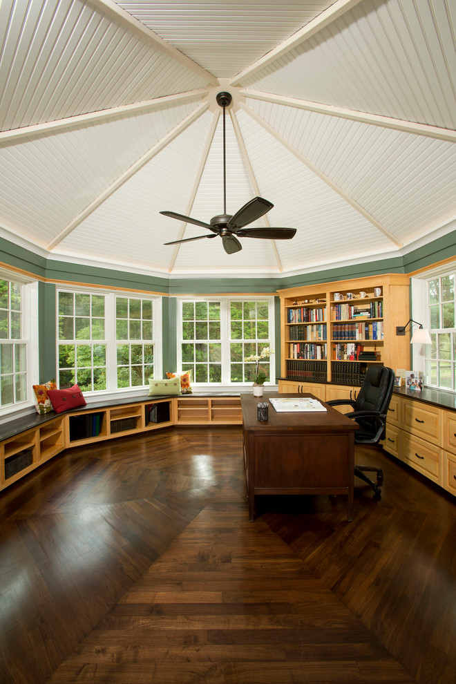 Ejemplo de despacho tradicional grande con paredes verdes, suelo de madera en tonos medios y escritorio independiente