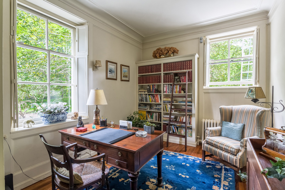 Idéer för att renovera ett mellanstort vintage hemmabibliotek, med grå väggar, mellanmörkt trägolv, ett fristående skrivbord och brunt golv