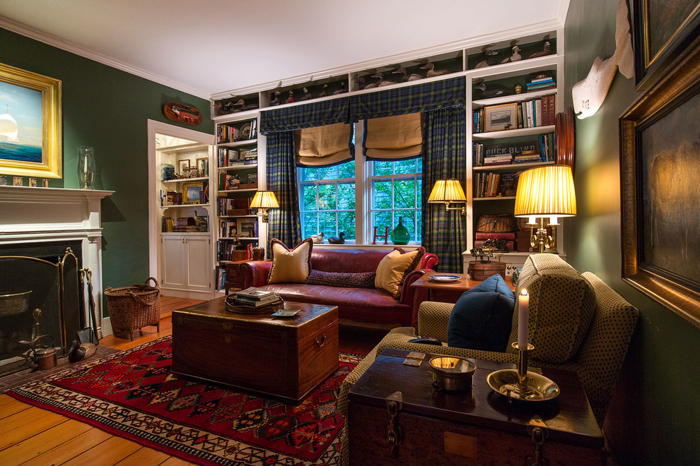 This is an example of a medium sized classic study in New York with green walls, medium hardwood flooring, a standard fireplace, a tiled fireplace surround and a freestanding desk.
