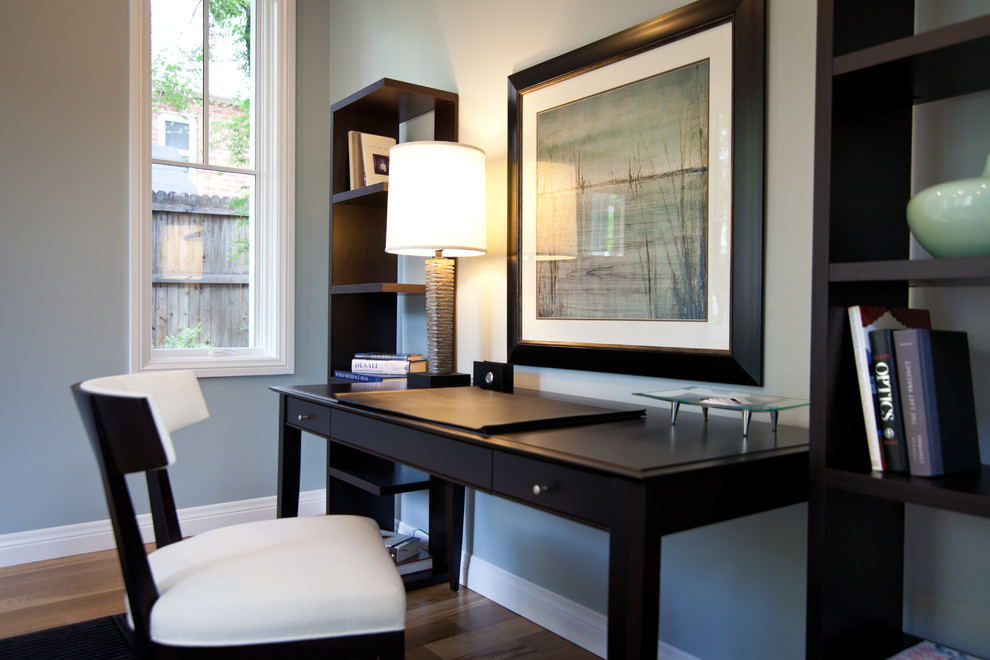 Idée de décoration pour un bureau minimaliste de taille moyenne avec un mur gris, un sol en bois brun, un bureau indépendant et un sol marron.